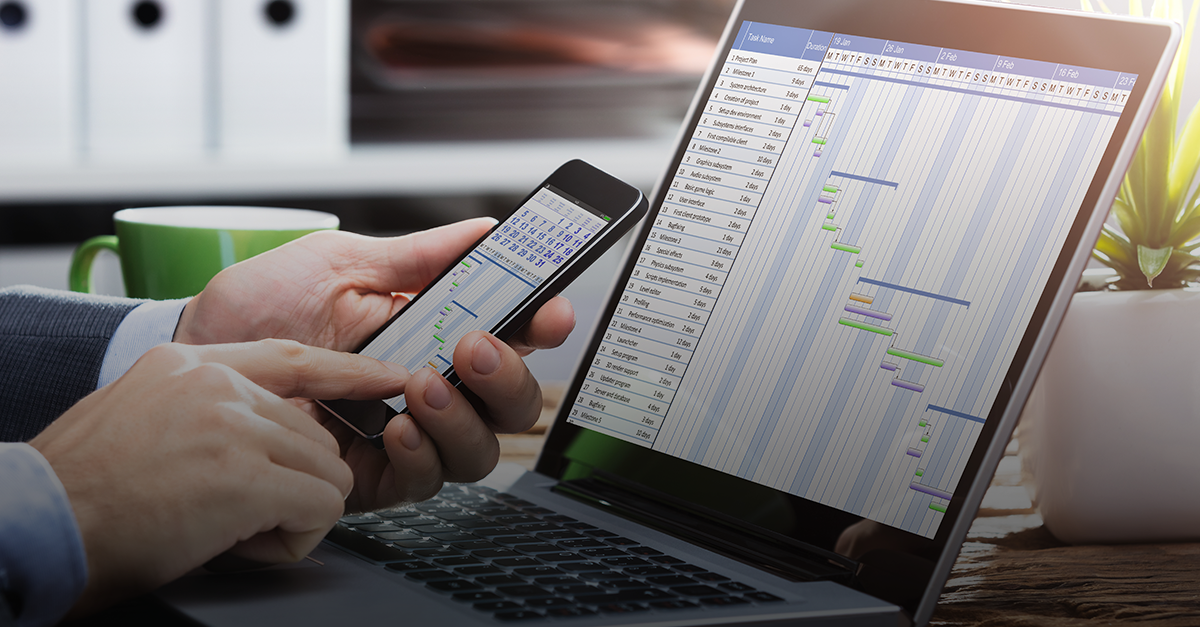 Empresário agendando compromissos pelo celular e computador