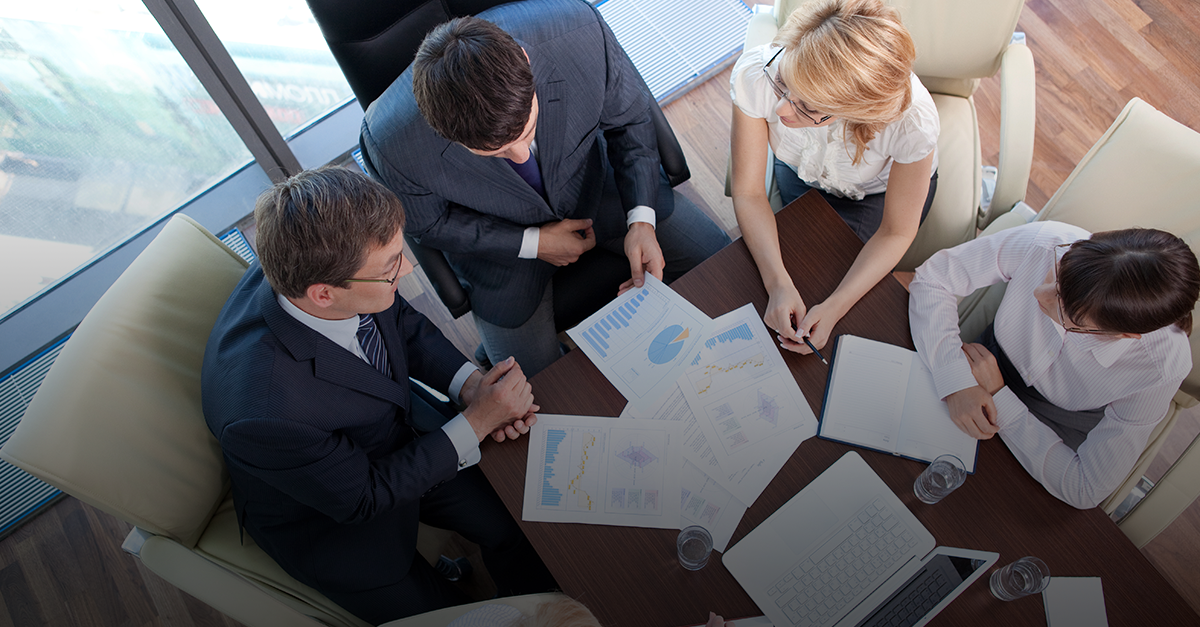 Foto vista de cima, executivos analisam relatórios em conjunto